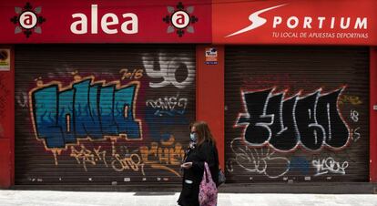 Una mujer pasa delante de un local de apuestas cerrado en Zaragoza.