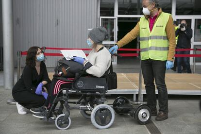 La presidenta de la Comunidad de Madrid, Isabel Díaz Ayuso (agachada) visita el hospital de campaña del Ifema en Madrid y saluda a una enferma por coronavirus, el 11 de abril.