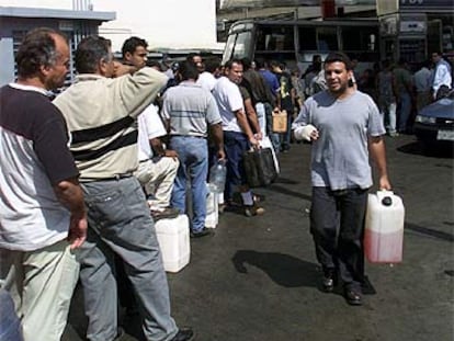 Decenas de venezolanos hacen cola en una estación de servicio para comprar gasolina, ayer en Caracas.