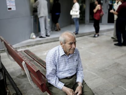 Um pensionista, sentado na fila de um caixa na Grécia.