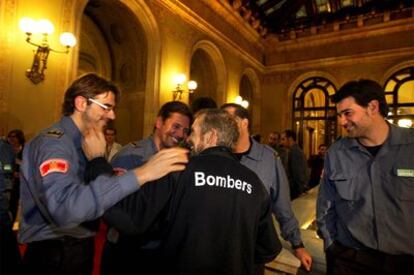 Carles Font (Delta 0), de espaldas, recibe el calor de los bomberos tras su comparecencia en el Parlament.