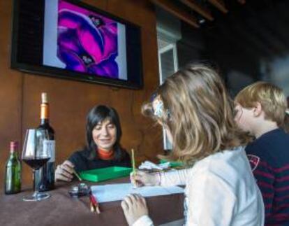 La responsable del "Espacio Creativo Pigmento", Rosa Diego (i), con dos niños en las Bodegas Ontañón (Logroño) donde ha desarrollado dos talleres de pintura con vino dirigidos a medio centenar de personas, de todas las edades.