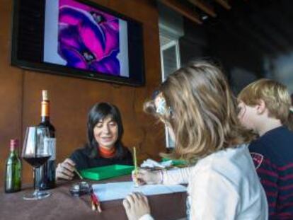 La responsable del "Espacio Creativo Pigmento", Rosa Diego (i), con dos niños en las Bodegas Ontañón (Logroño) donde ha desarrollado dos talleres de pintura con vino dirigidos a medio centenar de personas, de todas las edades.
