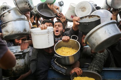 Palestinos se agolpan para recibir comida, antes de que entre en vigor el alto el fuego entre Hams e Israel, en Jan Yunis, en el sur de la Franja.