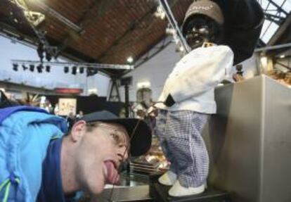 Un visitante bebe de una fuente que imita a la célebre escultura Manneken Pis, en la Feria del Chocolate en Bruselas, Bélgica.