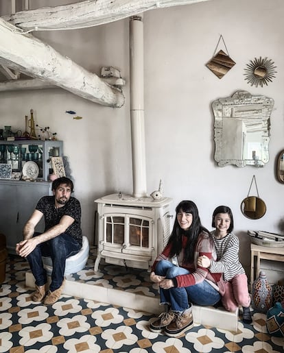 La diseñadora Inés Aguilar y su familia: Miguel Fernández de Molina y Valentina, en su casa en un pueblo con sólo siete habitantes. La casa de la diseñadora gira en torno a su hija. Vivir en la España vacía tiene sus inconvenientes. En tiempos de confinamiento, lógicamente, alguno más. “Estamos muy aislados, apenas hay una ambulancia para una zona enorme, no hay casi tiendas, el supermercado está a 15 kilómetros, y el hospital más cercano, a 100”, cuenta Inés Aguilar, directora creativa de la firma La Casita de Wendy. Por no hablar de esas comodidades más domésticas que en las ciudades se dan por sentado: “La casa se calienta con una chimenea y con leña, no tenemos lavadora, los suelos son de madera y crujen…”. Pero, claro, lo que trajo a este pueblo perdido de siete habitantes situado en una aldea muy pequeña cerca de Segovia a Inés Aguilar; a su pareja, Miguel Fernández (profesor de universidad), y a su hija, Valentina, también se ha vuelto más valioso en estos momentos. “La naturaleza contagia tranquilidad. Levantarnos con el canto de los pájaros, oler el campo, poder comenzar con el huerto. Todo eso ayuda a recuperar un ritmo olvidado”.