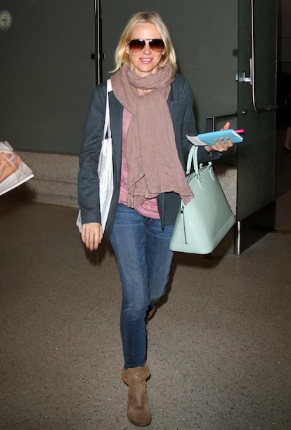 Naomi Watts es fiel a los básicos para viajar en avión. Nos quedamos con su bolso lady azul bebé.