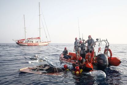 Miembros de Proactiva Open Arms sacan a una mujer del agua que se sujetaba aún con vida sobre una embarcación destruida por la guardia costera libia.