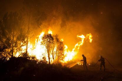  Dos bomberos trabajan en la extinción del incendio que se declaró anoche en Ribeira obligando a cortar la autovía del Barbanza. El incendio, según los últimos datos, ha quemado 175 hectáreas