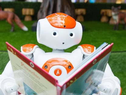 Un robot sostiene un libro durante una demostración de inteligencia artificial para niños en Londres.