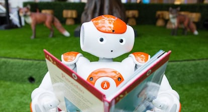 Un robot sostiene un libro durante una demostración de inteligencia artificial para niños en Londres.