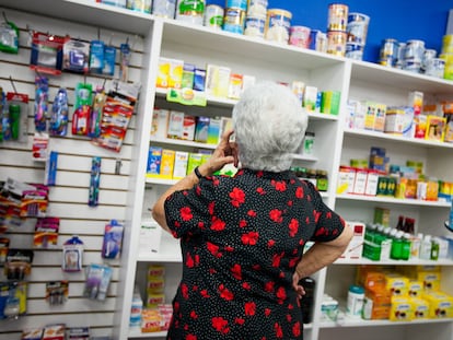 Una mujer inspecciona complementos alimenticios en un establecimiento donde se dispensan.