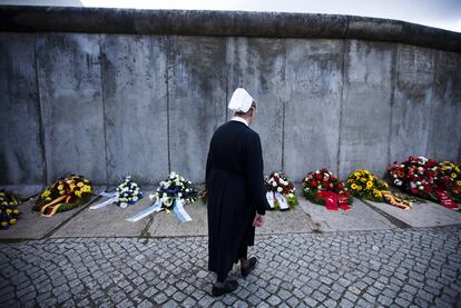 Una monja camina sobre la línea donde se alzaba el Muro durante la conmemoración del 50 aniversario de su construcción hoy en Berlín
