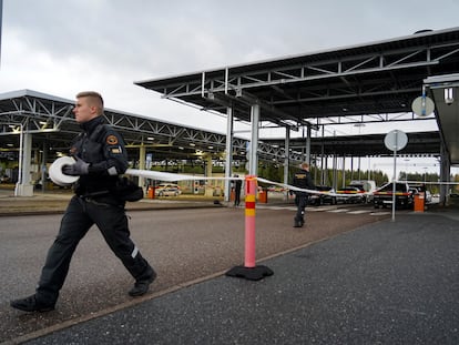 Un guardia coloca una cinta en el cruce fronterizo de Vaalimaa, en Finlandia.