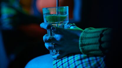 Una mujer sostiene una bebida en un bar.