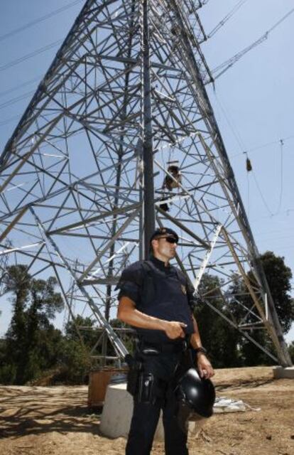 Un 'mosso' custodia la torre en la que se encadenaron cuatro activistas.