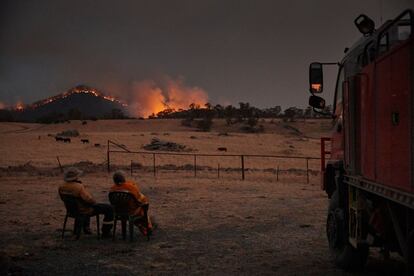 Dos voluntarios del Servicio de Bomberos Rurales observan como el fuego se acerca a las afueras de la ciudad de Tumbarumba, en Nueva Gales del Sur (Australia).