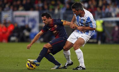 Xavi pelea el balón con Jeremy Toulalan.