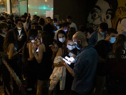 Vigilantes de la sala Apolo comprueban el pasaporte covid en la cola de acceso a la discoteca.