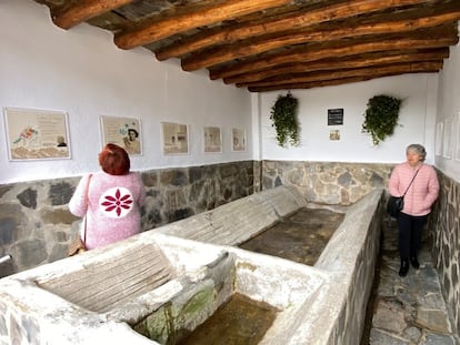 Dos mujeres visitan los poemas creados en Mecina Bombarrón y expuestos en los antiguos lavaderos del pueblo.