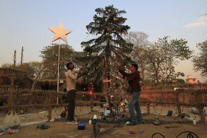 Unos hombres decoran un árbol de Navidad en un barrio cristiano de Islamabad, Pakistán.