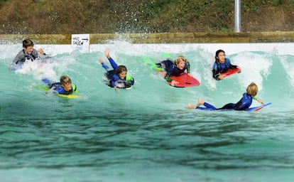 Ni&ntilde;os practican surf en las olas artificiales de Wavegarden.