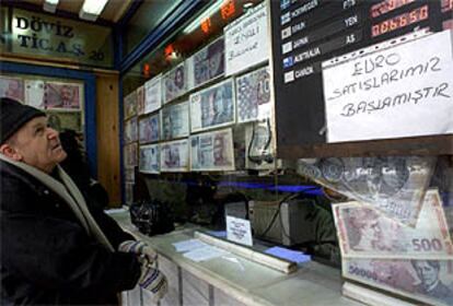 Un ciudadano turco mira los tipos de cambio en una oficina de Estambul, donde se anuncia la venta de euros.