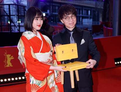 La actriz Nanoka Hara, que pone voz a Suzume, y el director Makoto Shinkai entran en la alfombra roja de la Berlinale con la silla que acompaña a la protagonista.