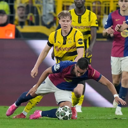 Barcelona's Ferran Torres, bottom, is challenged by Dortmund's Daniel Svensson during the Champions League quarterfinals second leg soccer match between Borussia Dortmund and Barcelona, at the Signa-Iduna Park in Dortmund, Germany, Tuesday, April 15, 2025. (AP Photo/Matthias Schrader)