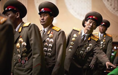 Por su semblante, nadie diría que están a punto de entrar en la fiesta de la conmemoración del 65 aniversario del Partido de los Trabajadores de Corea del Norte.