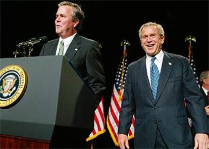 George W. Bush (derecha) y su hermano Jeb, en un acto para recaudar fondos, ayer en Florida.