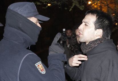 Un policía se dirige a un miembro de los piquetes que se concentraron en la entrada de las cocheras de la EMT en el barrio de La Elipa.