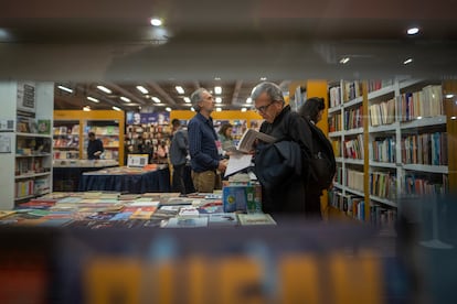 Un visitante revisa un libro en uno de los pabellones de la Feria.