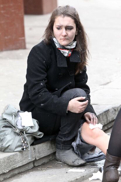 Una mujer, con la cara llena de cenizas, se tapa una herida en la rodilla en los alrededores de la estación de Park Kultury.