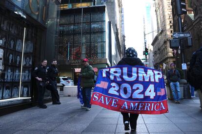 Una mujer camina por la Quinta Avenida con una bandera de apoyo al expresidente Donald Trump, el martes en Nueva York.