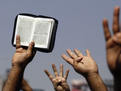 Islamistas levantan un Corán en una manifestación en El Cairo, el viernes. Los cuatro dedos al aire provienen de la acampada en Raba al Adauiya, desmantelada por el ejército. "Raba" significa cuarto en árabe.