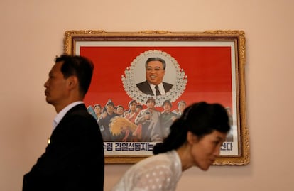 Dois guias caminham diante de uma imagem do falecido líder norte-coreano Kim Il Sung em uma escola de formação de docentes, durante uma visita para jornalistas estrangeiros a Pyongyang.