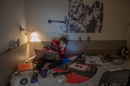 Un niño hace sus deberes escolares en casa por ordenador durante el confinamiento por el coronavirus en Barcelona.