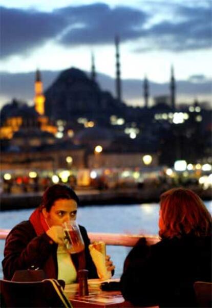 Dos jóvenes turcas toman un refrigerio en el puente de Gálata de Estambul.