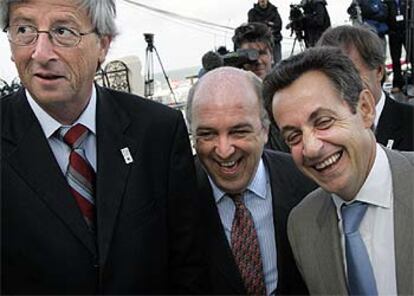 Juncker, Almunia y Sarkozy (de izquierda a derecha) bromean después de posar para la foto de familia.