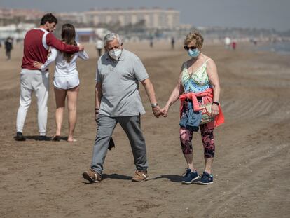 Dos personas caminan por la playa de la Malvarrosa, en Valencia, en marzo.
