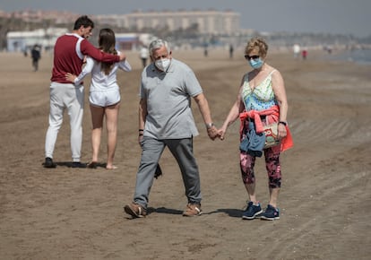 Dos personas caminan por la playa de la Malvarrosa, en Valencia, en marzo.