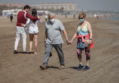 Dos personas caminan por la playa de la Malvarrosa, en Valencia, en marzo.