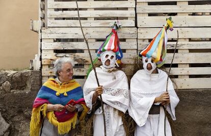 Una mujer y dos jóvenes vestidos de 'Zamarraches', personajes del carnaval tradicional de Casavieja, en Ávila.
