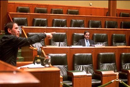 Otegi, ayer durante su intervención en el Parlamento. Al fondo, Barreda, junto a los escaños vacíos.