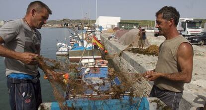 Dos pescadores arreglan sus redes en Barbate.