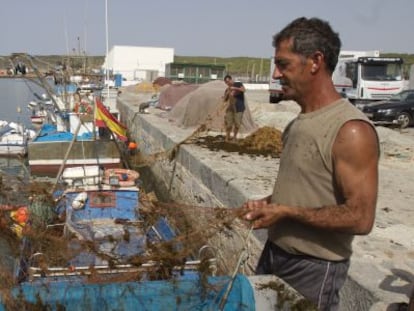 Dos pescadores arreglan sus redes en Barbate.