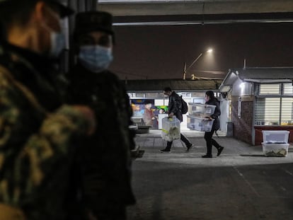 Trabajadores electorales llevan las cajas con los votos, resguardados por el Ejército chileno, este sábado, en Santiago de Chile.