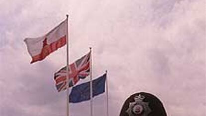 Un policía de Gibraltar, ante las banderas de la colonia.