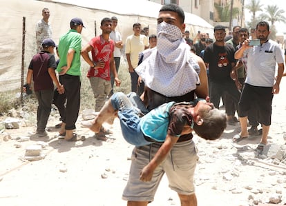 Un joven palestino trasladaba el viernes a un niño herido tras un ataque israelí sobre Deir Al-Balah, en la zona central de la franja de Gaza.